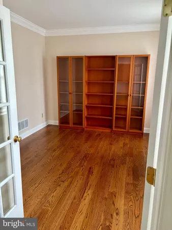 a view of empty room with wooden floor and closet