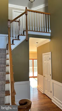 a view of a hallway with wooden floor and staircase