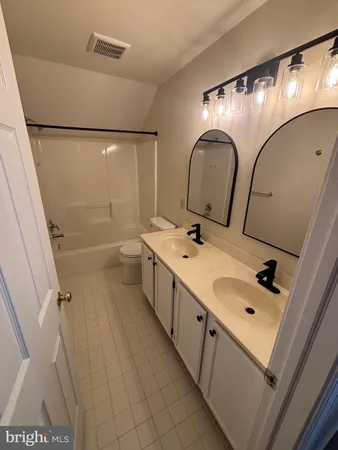a bathroom with a double vanity sink and mirror with shower
