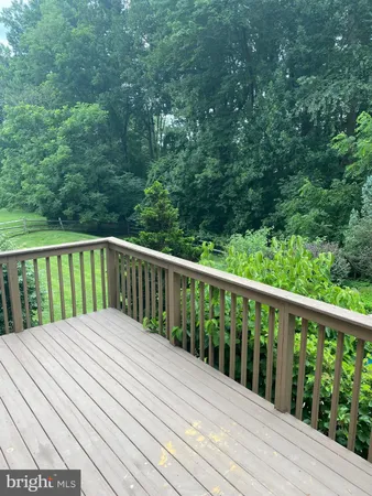 a balcony with wooden floor and trees in the back