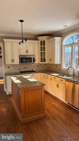 a large kitchen with stainless steel appliances granite countertop a stove a sink and a refrigerator