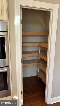 a view of walk in closet with wooden floor