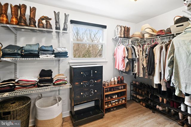 a view of walk in closet with clothes and shoes