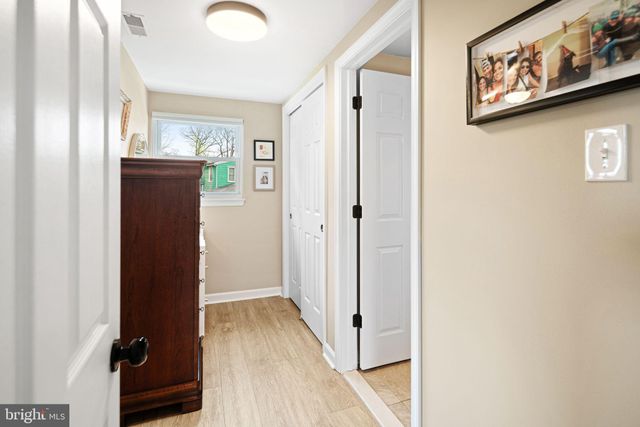 a view of a hallway with wooden floor and closet