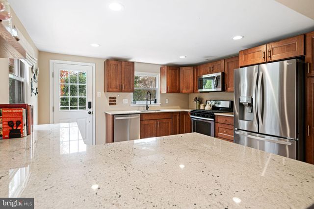 a kitchen with granite countertop a refrigerator and a sink
