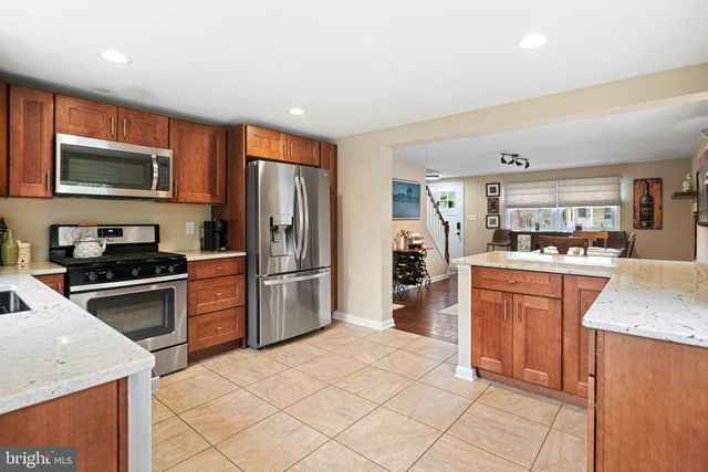 a kitchen with granite countertop a refrigerator stove top oven and sink