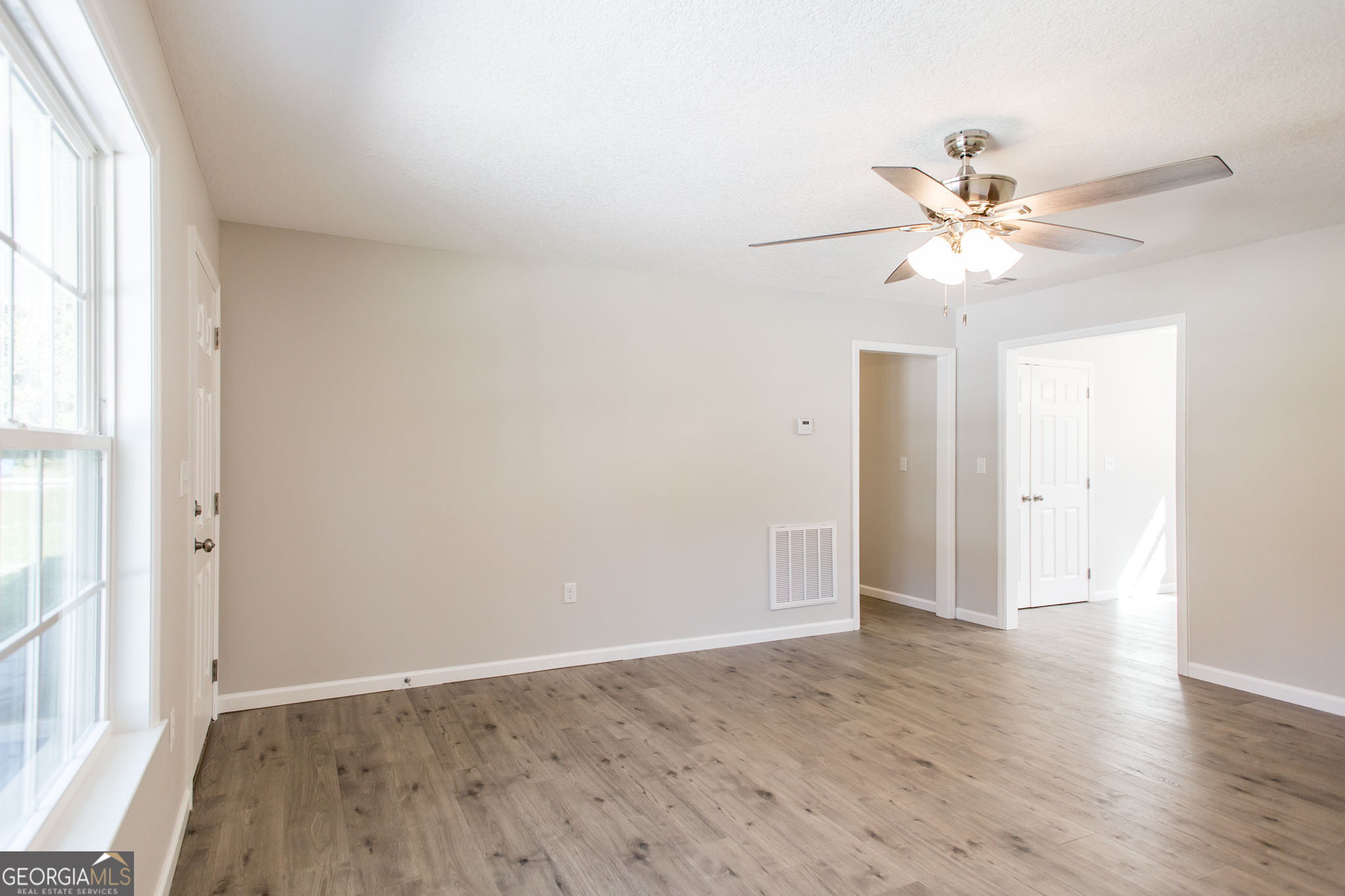2350 Edgewood Street Waycross, GA 31501 - Photo 6 of 27 an empty room with a window and a ceiling fan