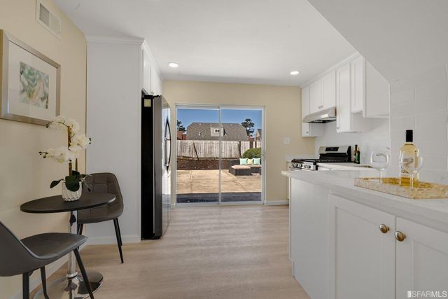 a kitchen with stainless steel appliances granite countertop a refrigerator and a stove top oven