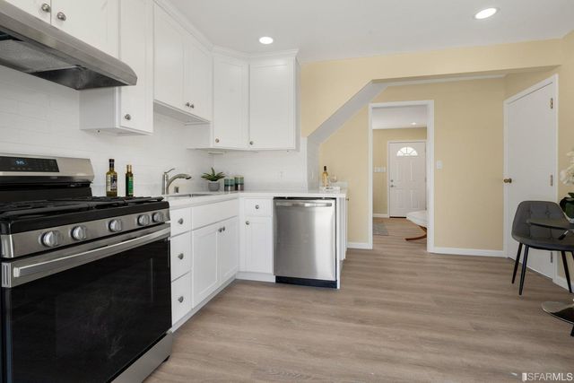a kitchen with a sink a stove and cabinets
