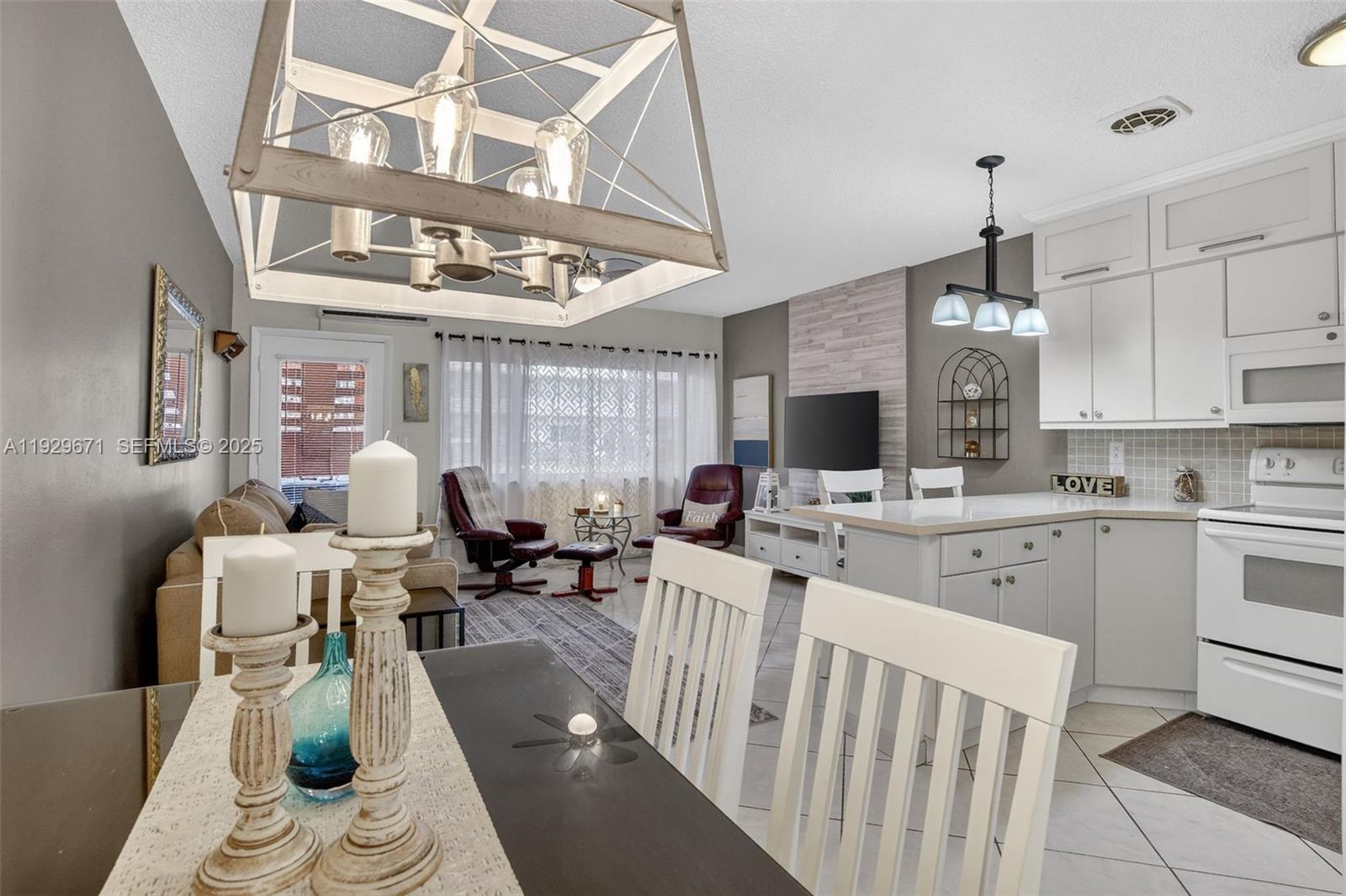 800 Southwest 10th Terrace, Unit 4T Hallandale Beach, FL 33009 - Photo 19 of 39 a living room with furniture a chandelier and kitchen view
