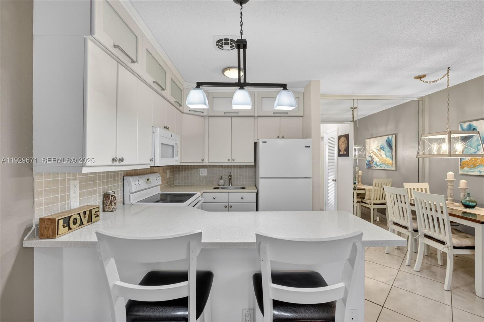 800 Southwest 10th Terrace, Unit 4T Hallandale Beach, FL 33009 - Photo 5 of 39 a kitchen with stainless steel appliances a table and chairs in it