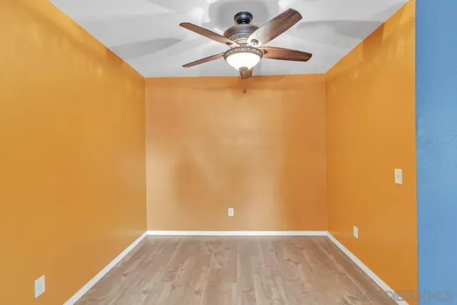 a view of a hallway with wooden floor and a living room