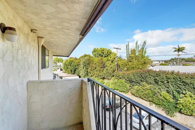 a view of a balcony with flower plants