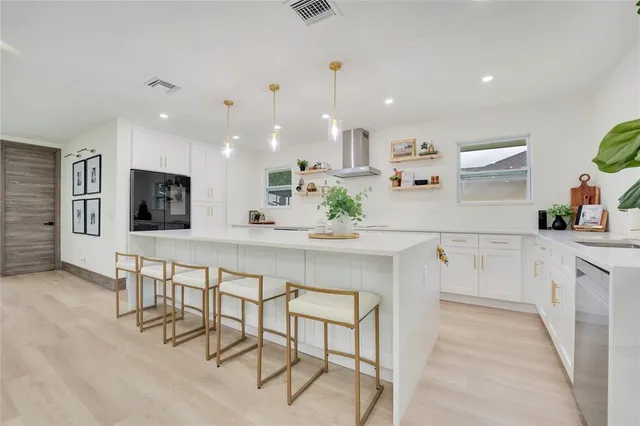 a kitchen with stainless steel appliances kitchen island granite top and refrigerator