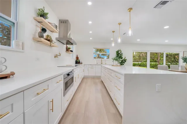 a large kitchen with cabinets and wooden floor