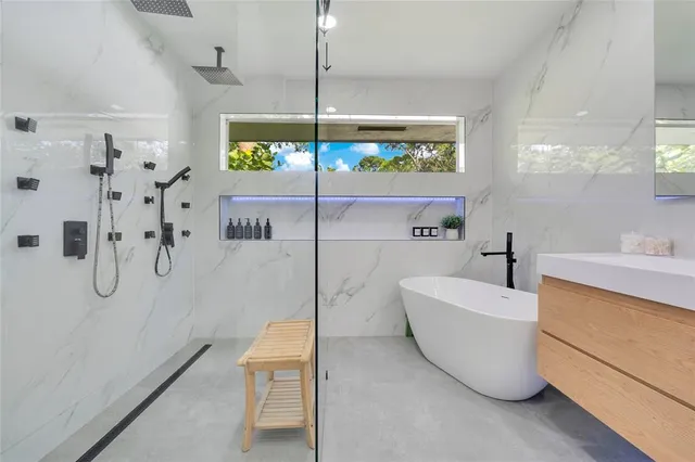 a bathroom with a tub a sink and a shower