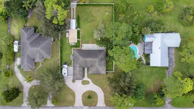 an aerial view of a house with swimming pool and garden