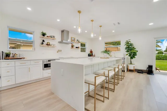 a kitchen with white cabinets and chairs