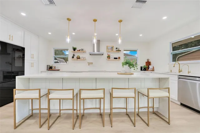 a kitchen with kitchen island cabinets and chairs in it