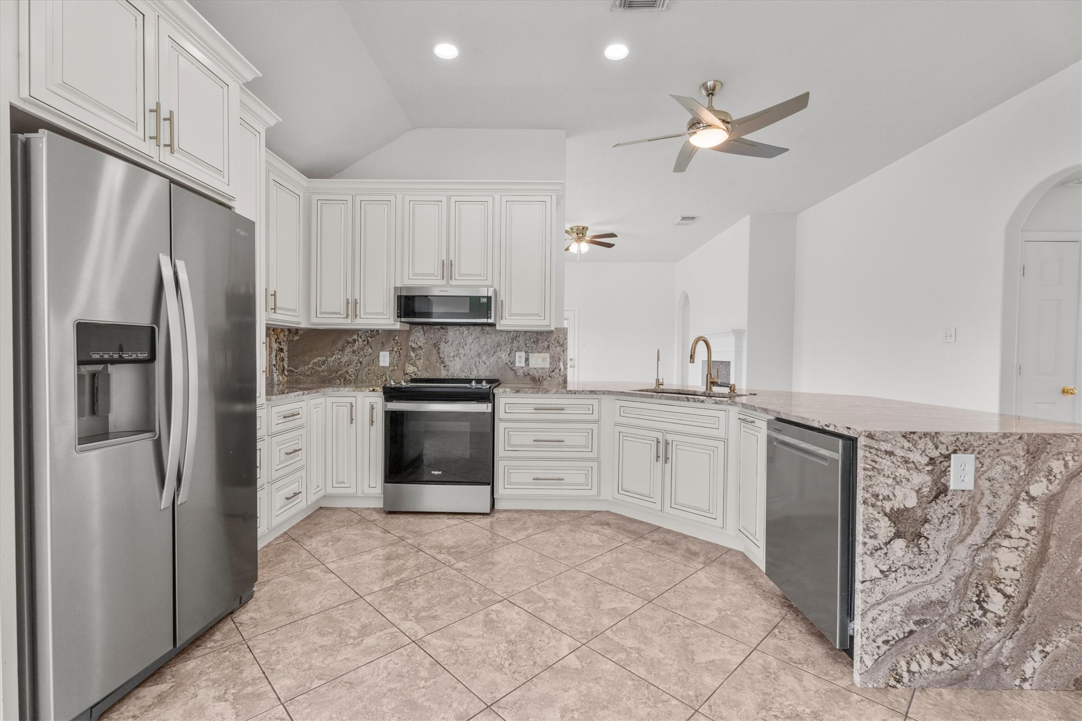 2507 Grayfeather Court Spring, TX 77388 - Photo 2 of 37 Beautifully updated kitchen with a stunning granite waterfall countertop, stainless steel appliances, custom cabinets, and open to the living area.