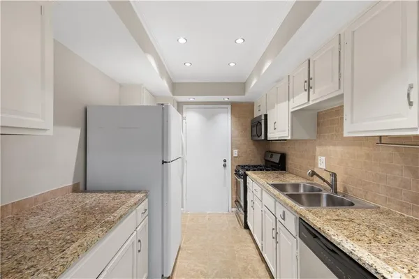 a kitchen with stainless steel appliances granite countertop a sink stove and refrigerator