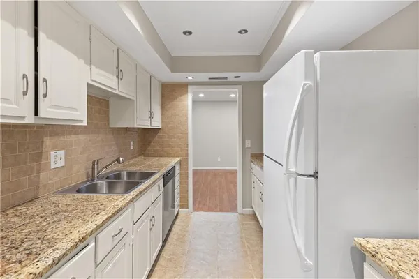 a kitchen with granite countertop a sink and refrigerator