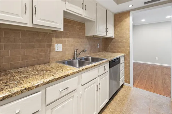 a kitchen with granite countertop white cabinets and a sink