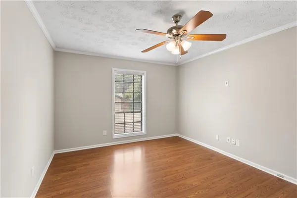 a view of a room with wooden floor and ceiling fan