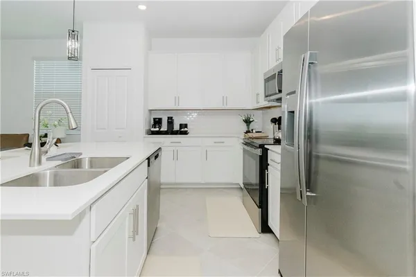 a kitchen with a sink refrigerator and cabinets
