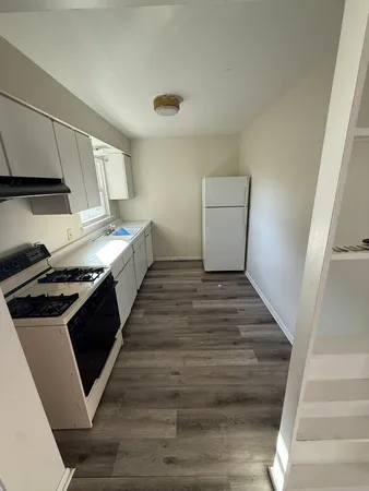 a view of a kitchen with wooden floor and electronic appliances