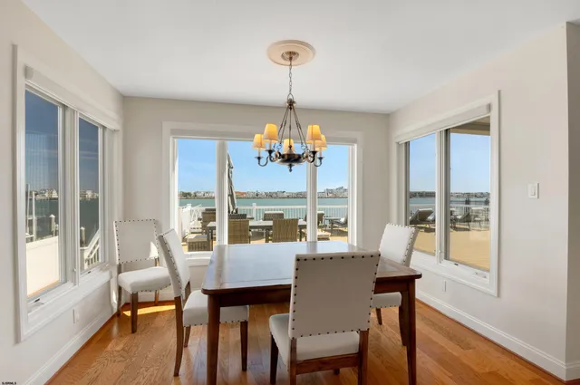 a dining room with furniture a chandelier and wooden floor