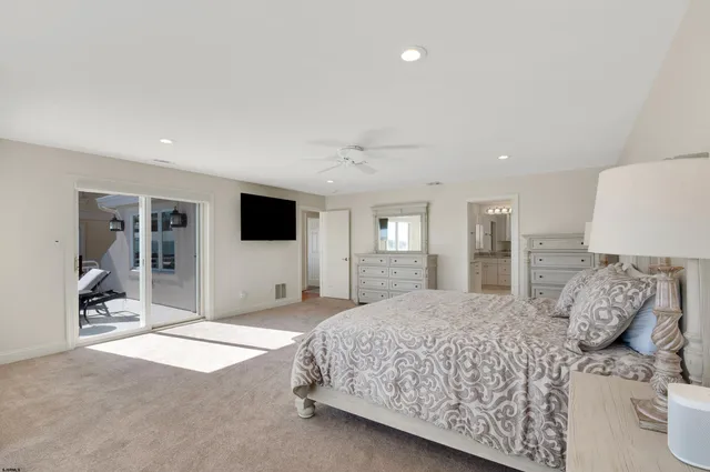 a spacious bedroom with a large bed and a flat screen tv