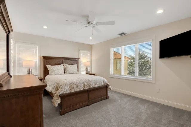 a spacious bedroom with a bed and a flat screen tv