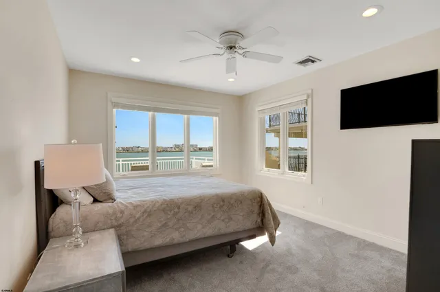 a bedroom with a bed window and a flat screen tv