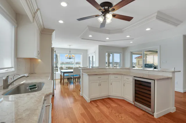 a kitchen with stainless steel appliances granite countertop a stove oven a sink dishwasher and white cabinets with wooden floor