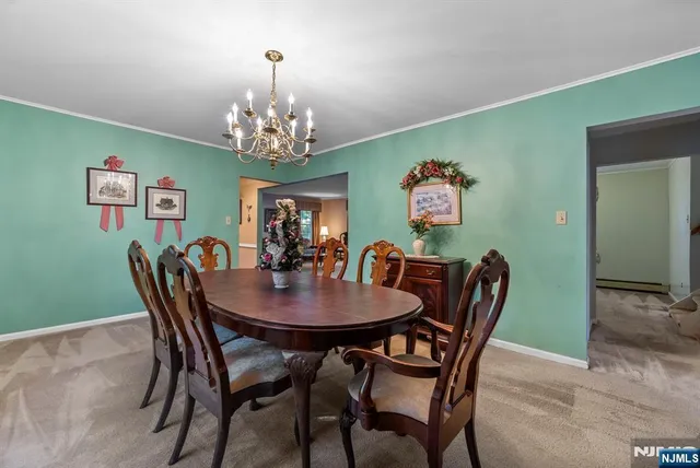 a view of a dining room with furniture a chandelier and wooden floor