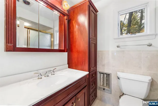 a bathroom with a sink a toilet and a mirror