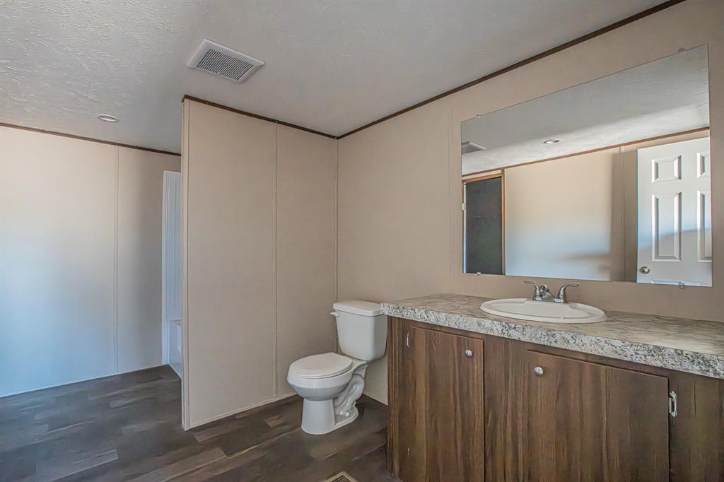 245 Lelon Lane Springtown, TX 76082 - Photo 16 of 37 a bathroom with a granite countertop sink and a mirror