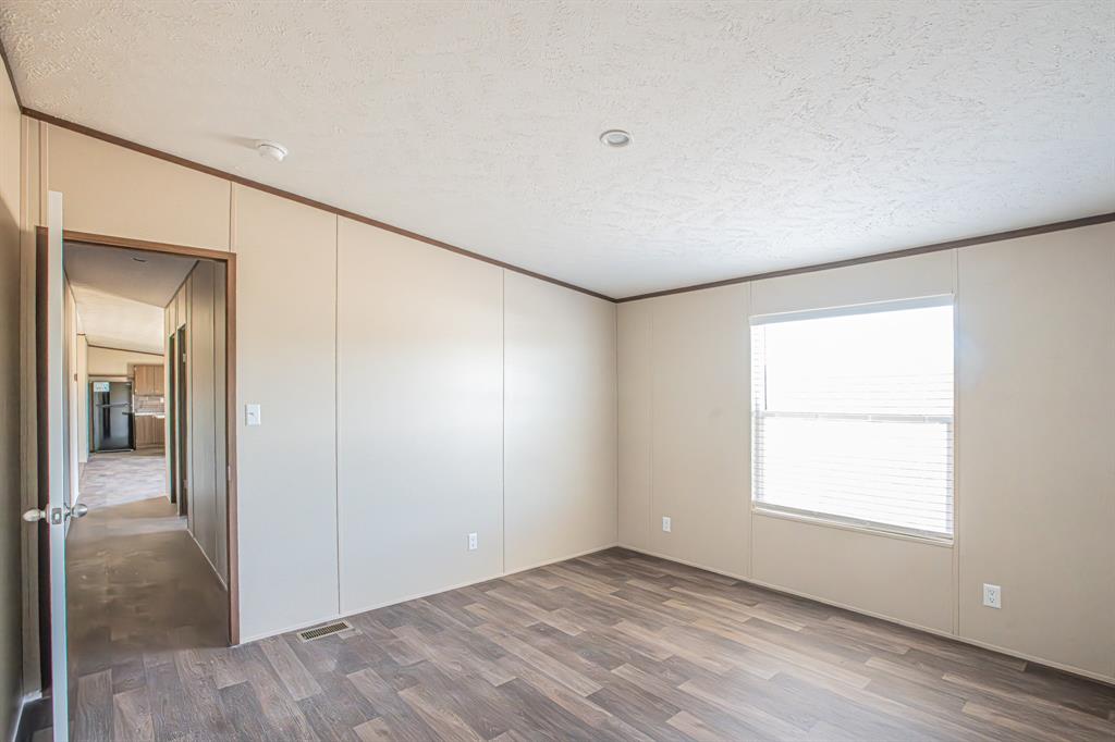 245 Lelon Lane Springtown, TX 76082 - Photo 24 of 37 an empty room with wooden floor and windows