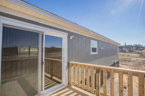 a view of a balcony with wooden floor and fence