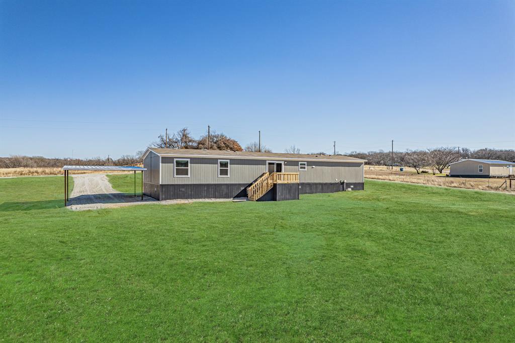 245 Lelon Lane Springtown, TX 76082 - Photo 37 of 37 a view of a house with a big yard and a large trees