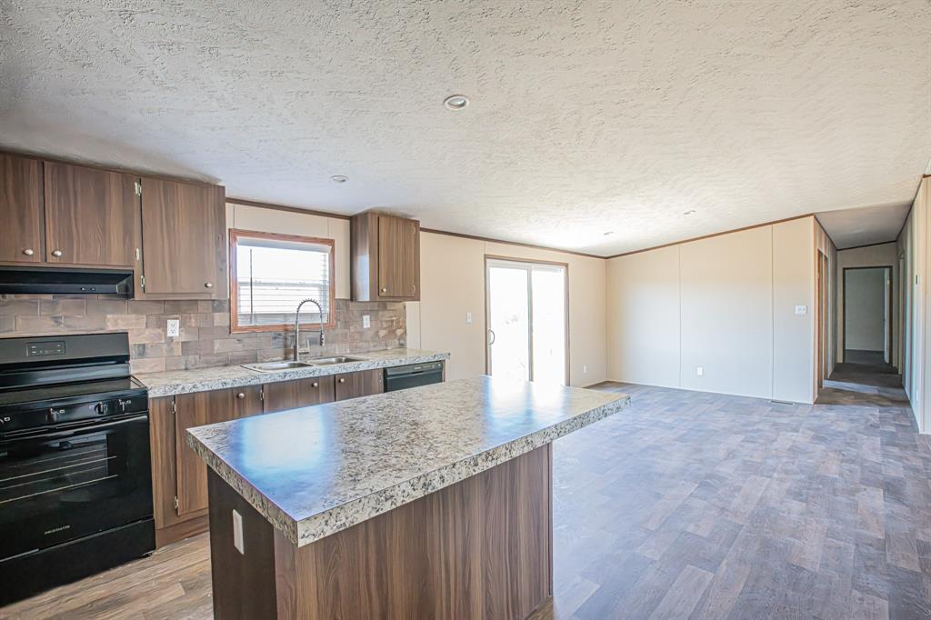 245 Lelon Lane Springtown, TX 76082 - Photo 10 of 37 a kitchen with kitchen island granite countertop a stove and a sink