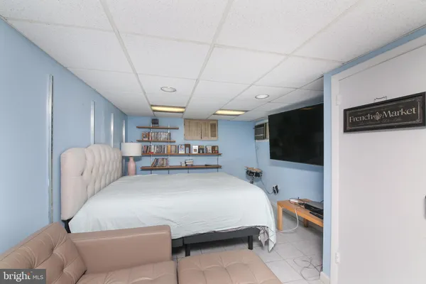 a bedroom with a bed a flat screen tv and a couch