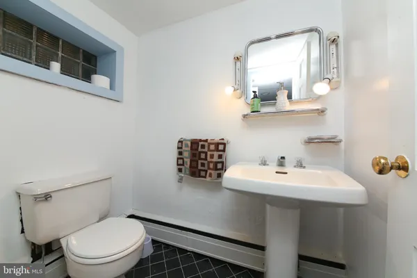 a bathroom with a toilet a sink and mirror