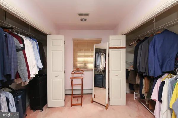 a view of walk in closet with clothes and shoes