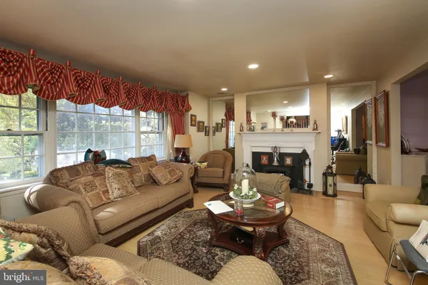 a living room with furniture fireplace and a large window