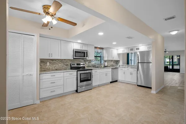 a kitchen with white cabinets and stainless steel appliances