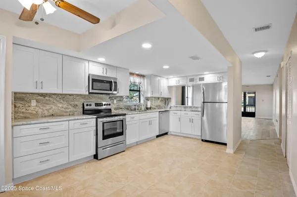 a kitchen with white cabinets and stainless steel appliances