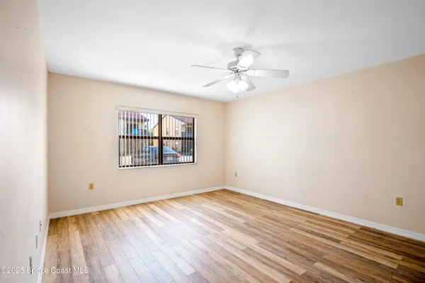 an empty room with closet and a ceiling fan