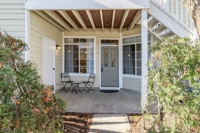 front view of a house with a large window and sitting area
